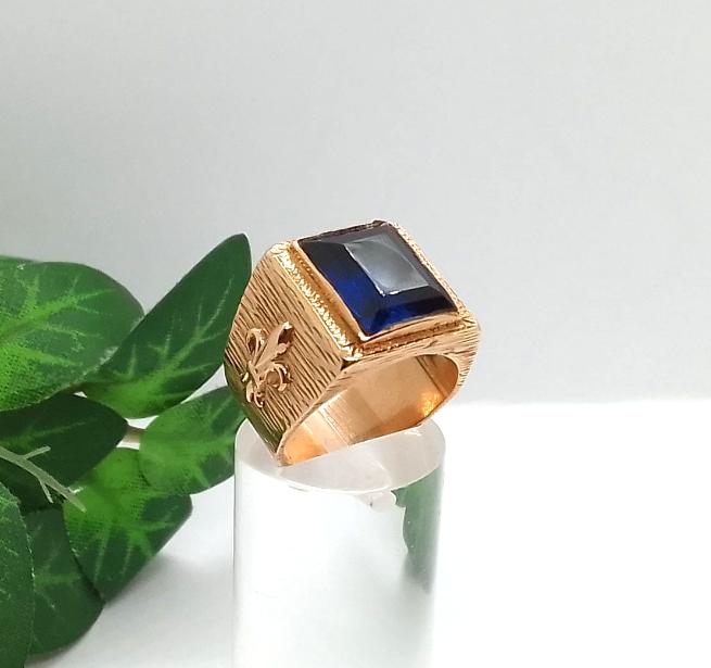 Sello Oro 18K con Circonia azul y flor de Liz a los lados.